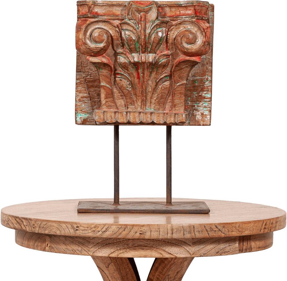 Hand-carved wooden panel with intricate floral details mounted on a rustic wooden pedestal table, showcasing artisan craftsmanship and timeless charm.