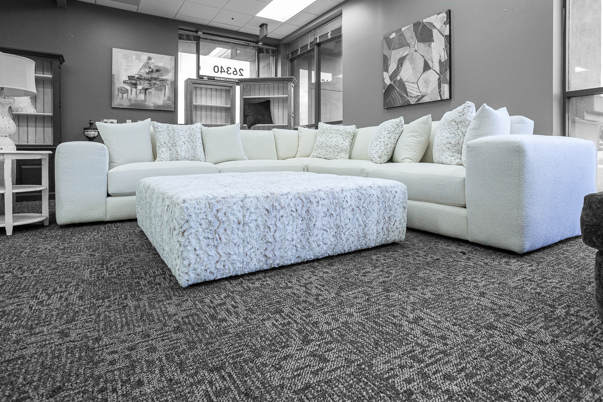 Plush white chaise sectional sofa with rolled arms and throw pillows.