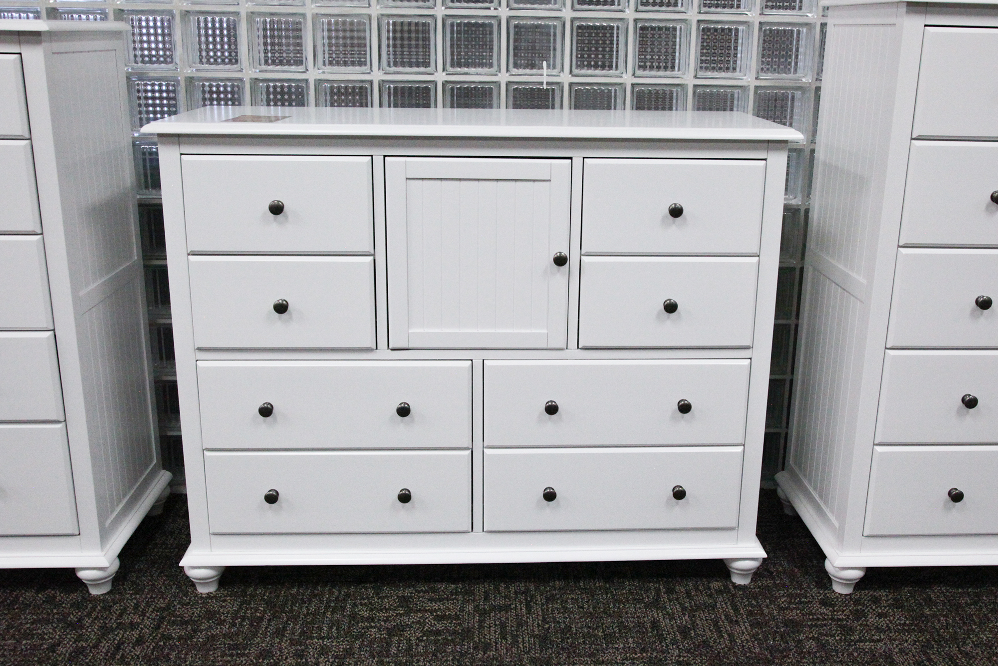 A solid wood eight-drawer dresser that features a center cabinet.