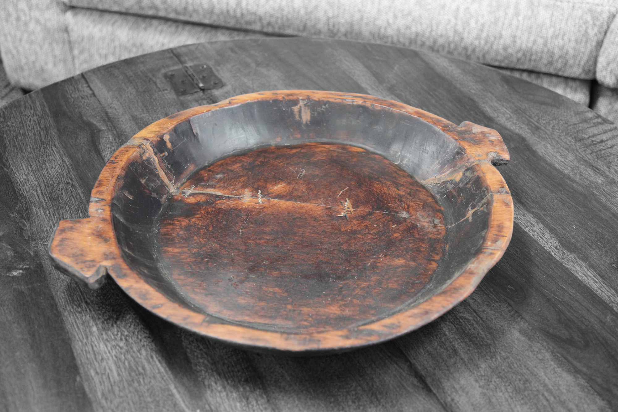 Dark reclaimed wood chapati bowl with rich patina on round wood table.