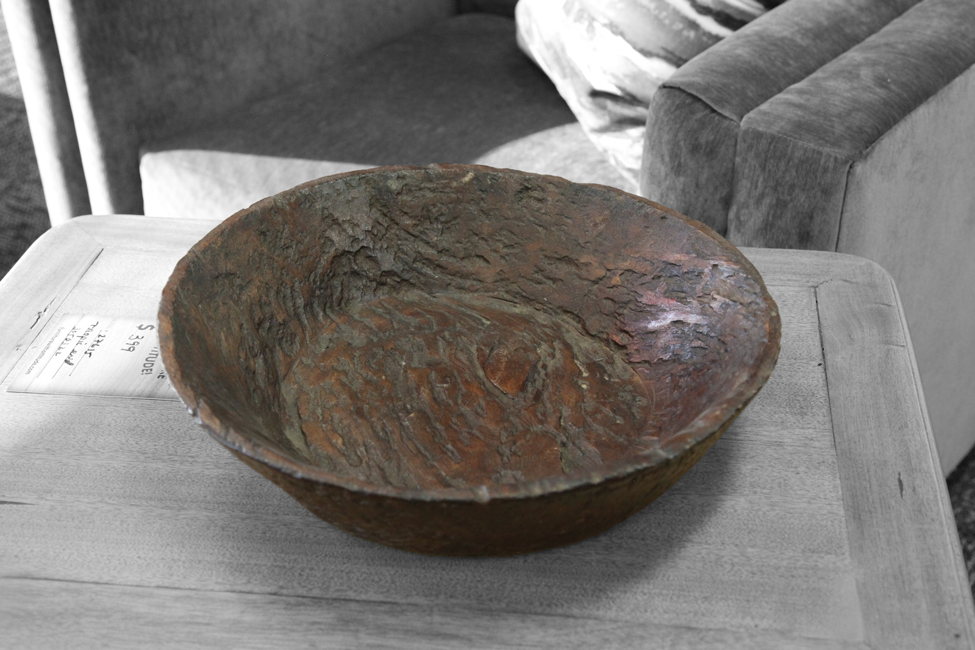 Hand-carved reclaimed wood dough bowl with rustic texture on side table.